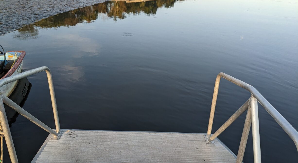 A photograph of the end of an access platform on a river.