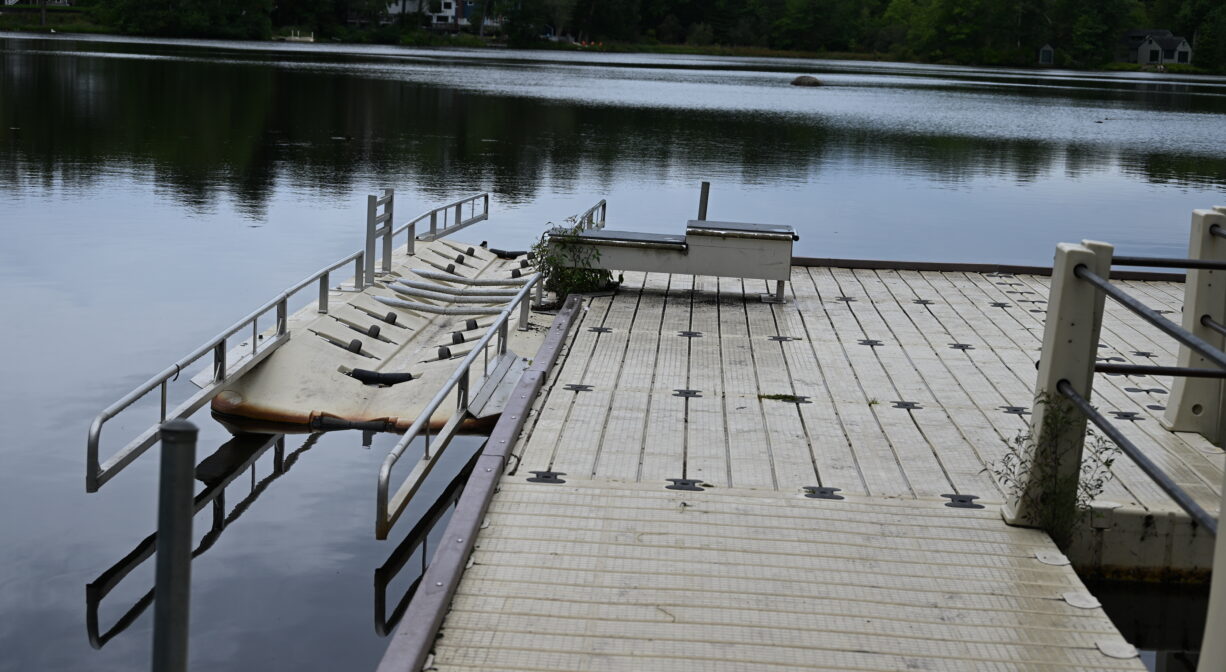 A photograph of an accessible kayak launch ramp on a pond.