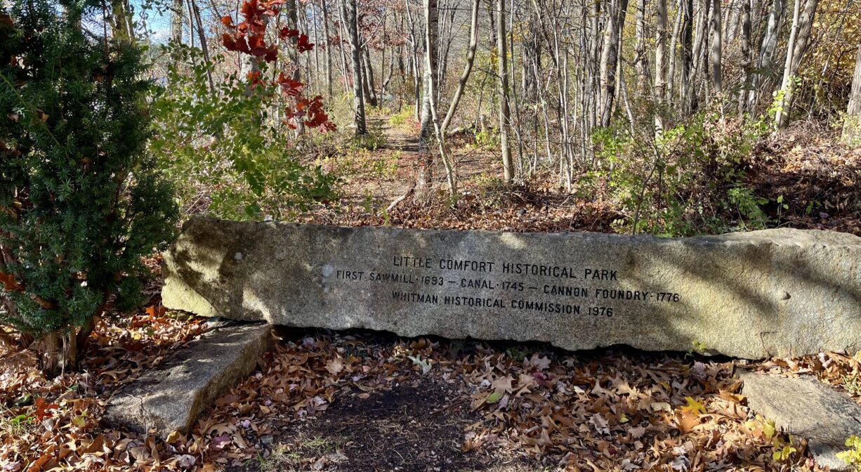 A photograph of a property sign at a forest trailhead.