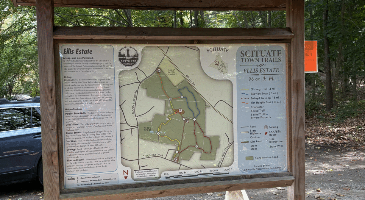 A photograph of an informational kiosk in a parking area.