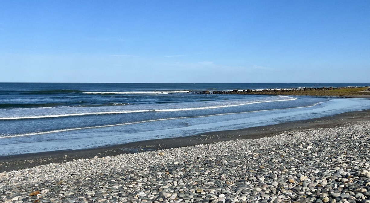A photograph of a stony ocean beach.