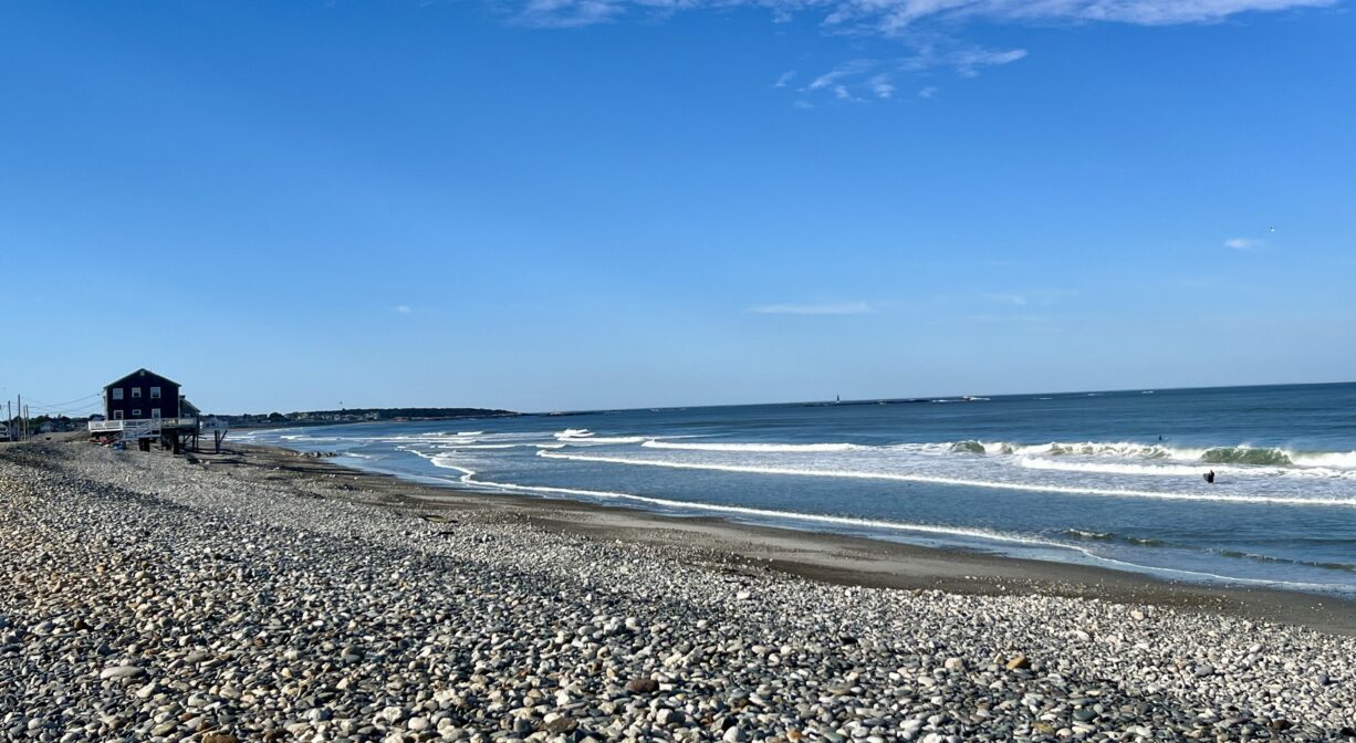 A photograph of a stony ocean beach.