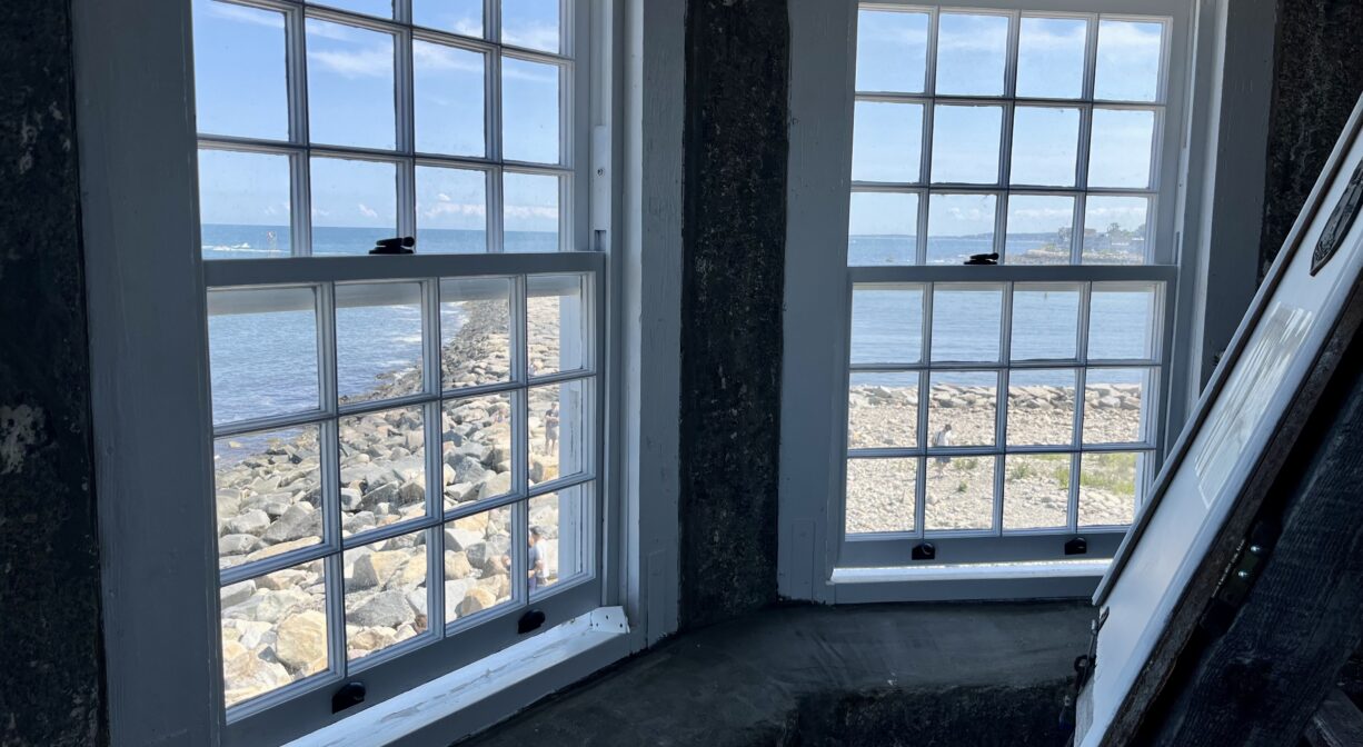 A photograph of the interior of a lighthose with an ocean view.