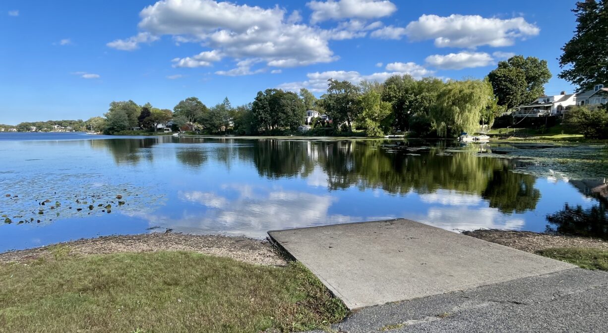A photograph of a boat launch ramp on a pond.