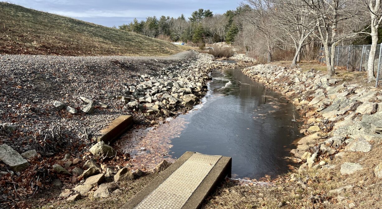 A photograph of a fish ladder connecting with a stream.