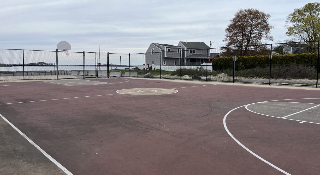 A photograph of a basketball court in a park.