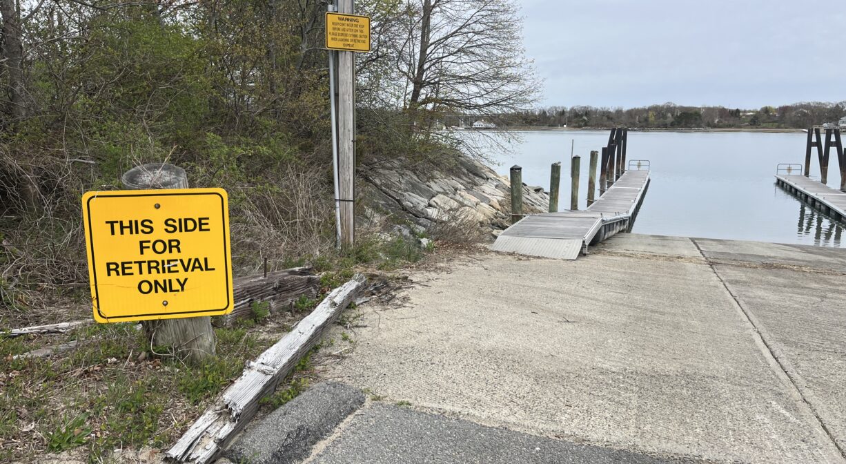 A photograph of a launch ramp with a pier beside it, on a river.