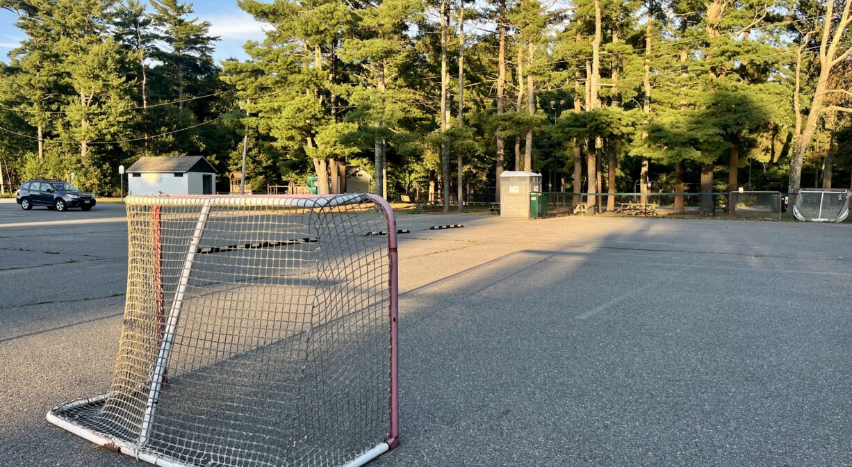 A photograph of a street hockey area and a large paved parking area.
