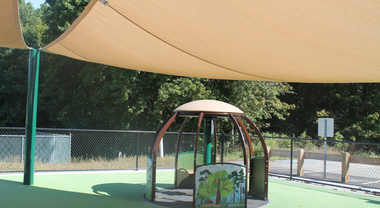 A photograph of a shade structure at a playground.