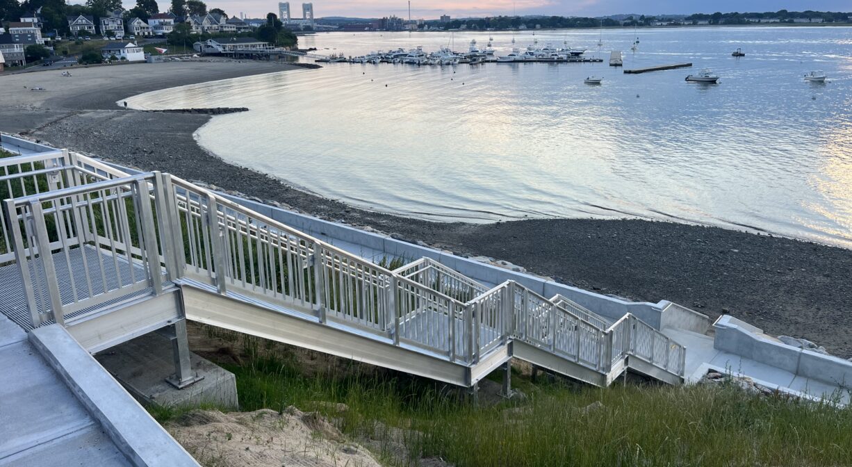 A photograph of a long staircase leading down to a beach.