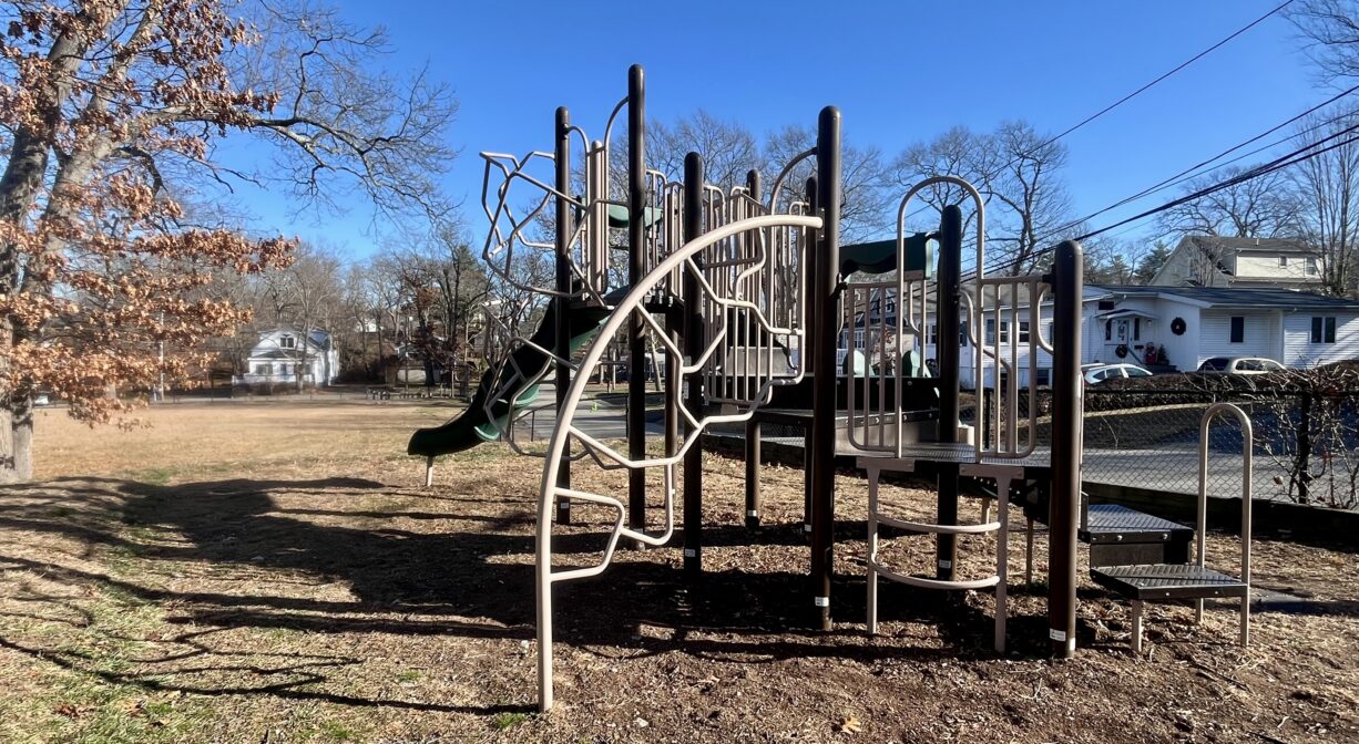 A photograph of a contemporary play structure in a park.