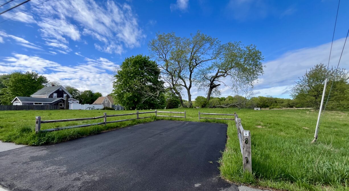 A photograph of a 2-vehicle parking lot beside an open field.