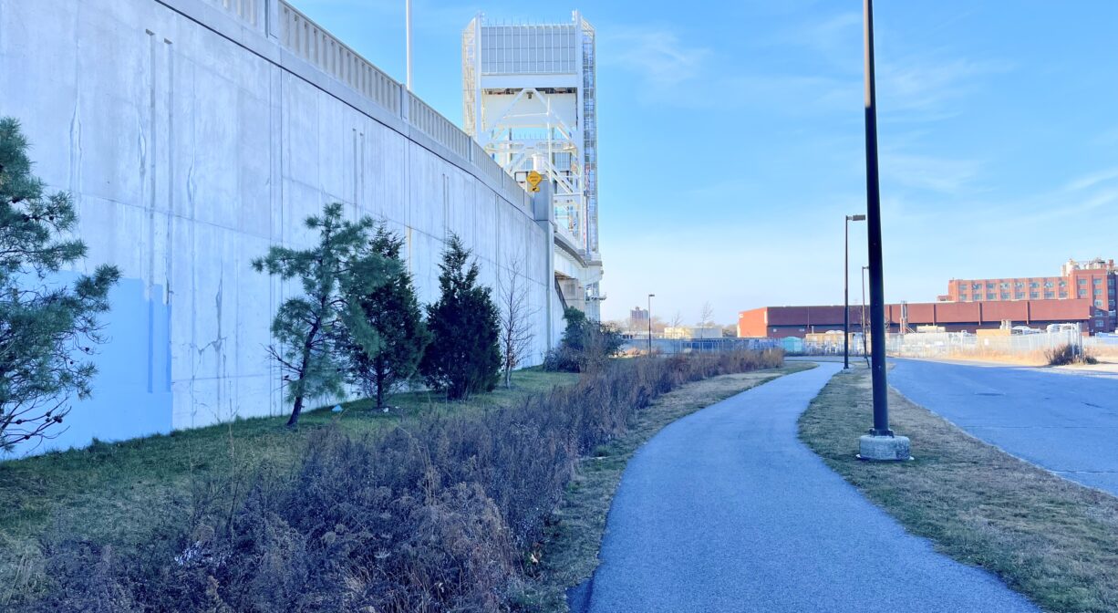 A photograph of a paved trail extending along a roadway.