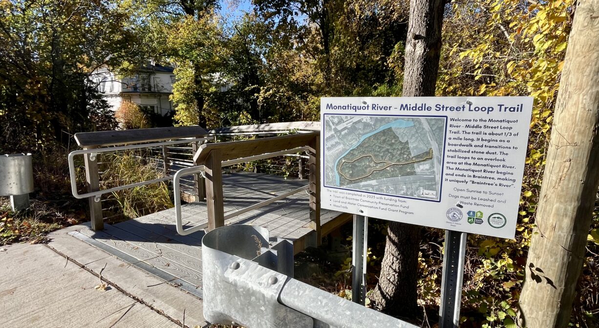 A photograph of a trailhead with a property sign and a ramp.