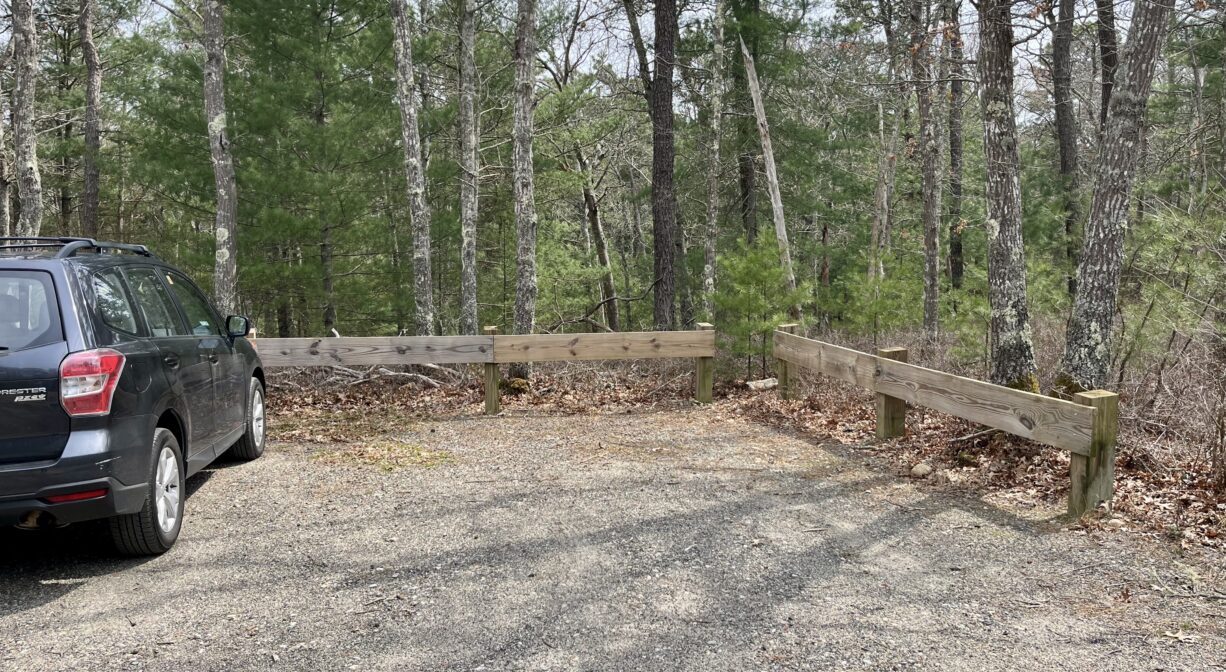 A photograph of a small parking area next to a forest.