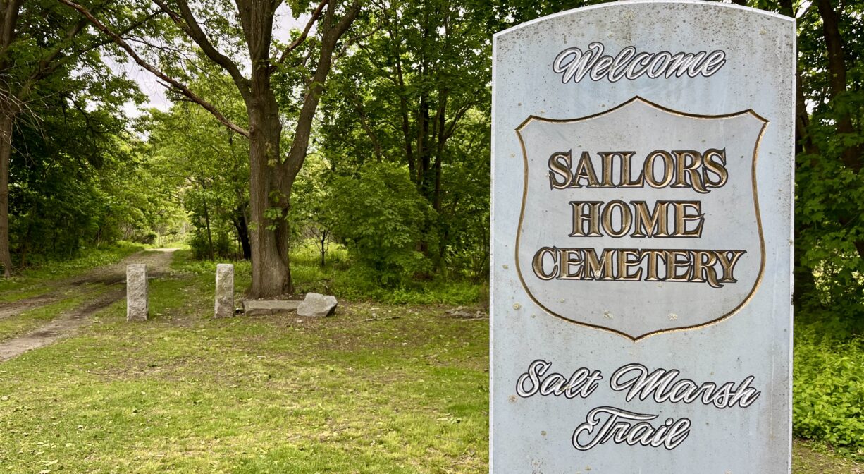A photograph of a property sign in a grassy park.