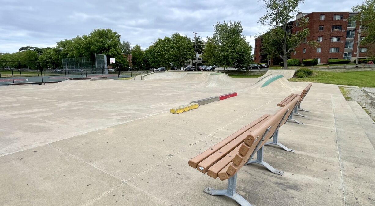 A photograph of a bench overlooking a skate park.