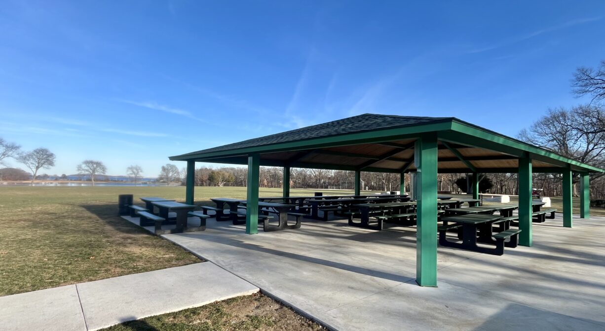 A photograph of a large picnic pavilion in a grassy park.