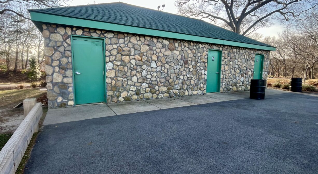 A photograph of a stone building with green trim.