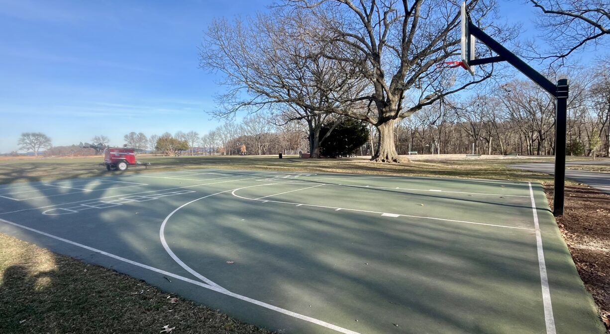 A photograph of a basketball court in a park.