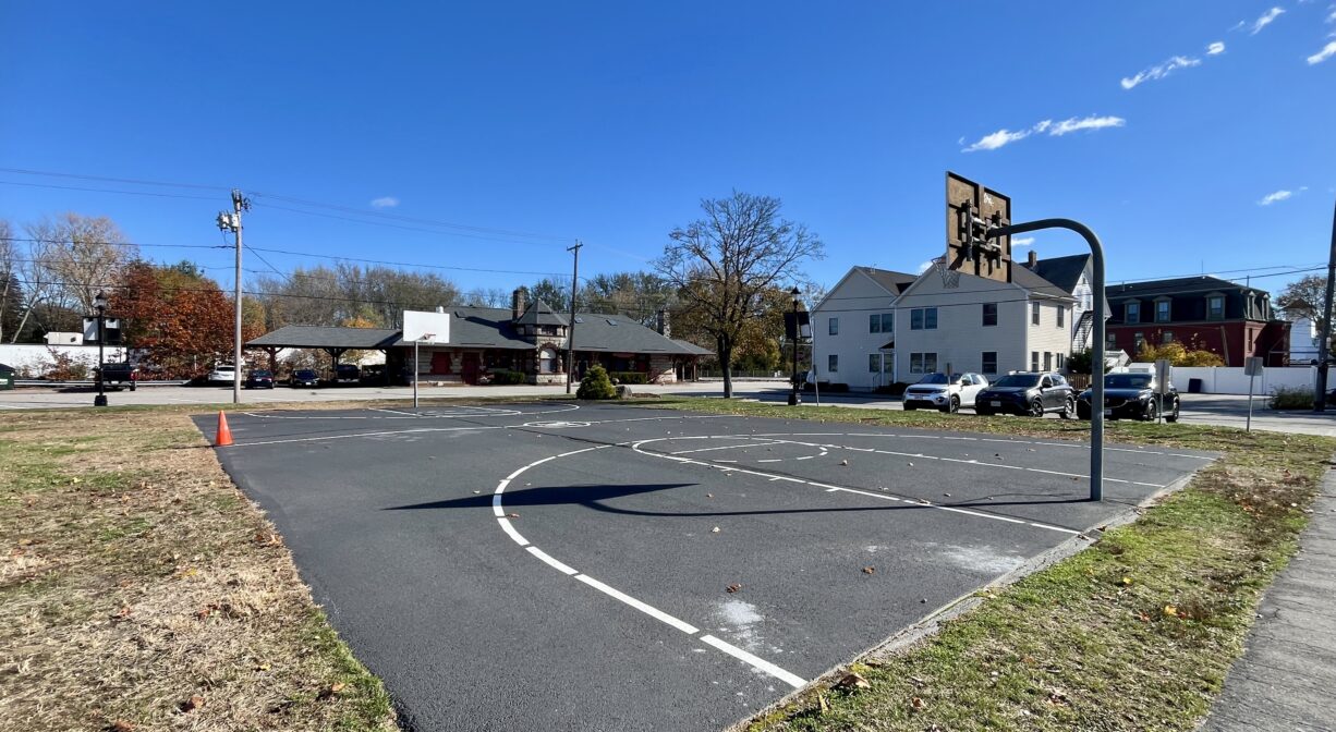 A photograph of a basketball court in a park.