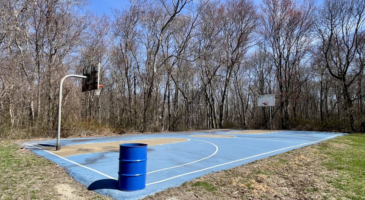 A photograph of a basketball court in a park.