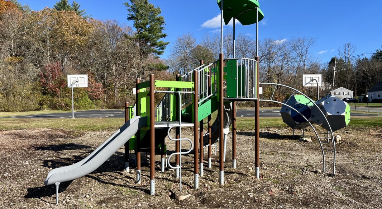 A photograph of a green and brown play structure in a park.