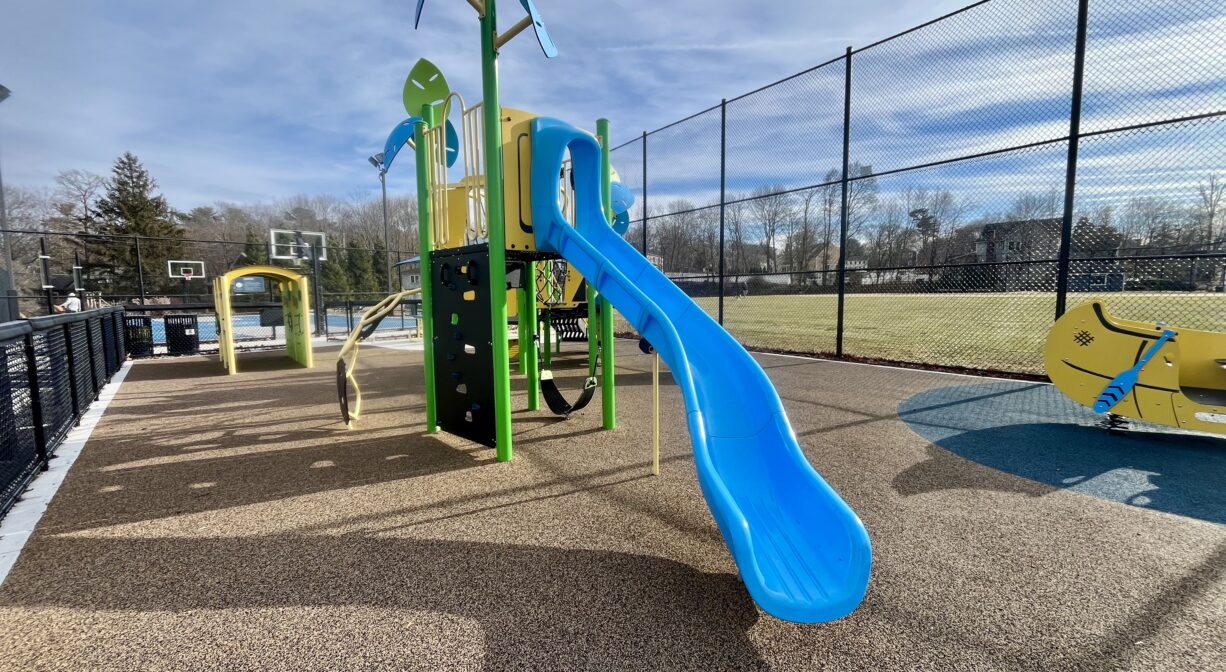 A photograph of a contemporary playground with a blue slide.