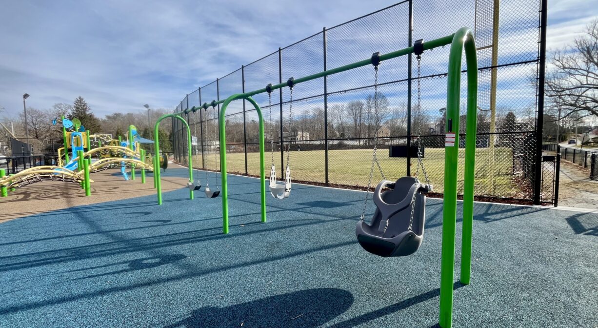 A photograph of a playground with swings.
