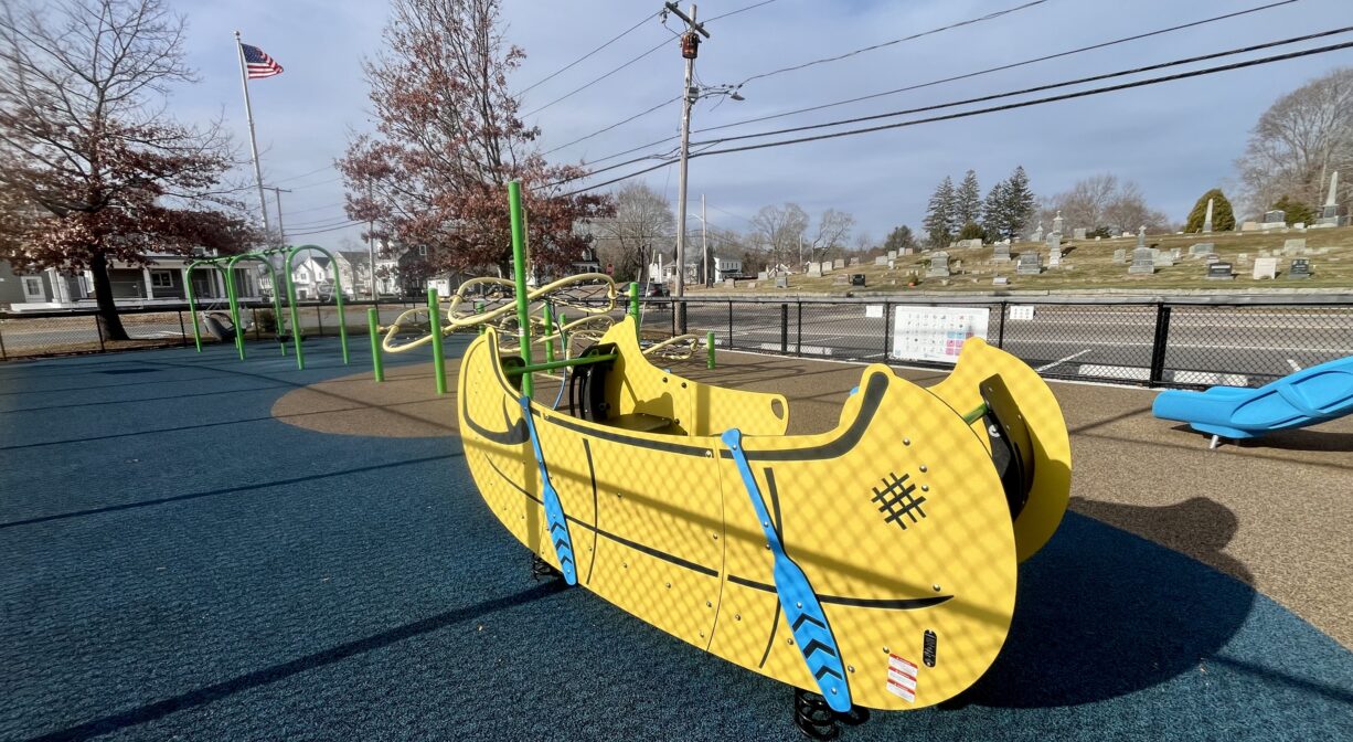 A photograph of a yellow boat-shaped play structure in a playground.