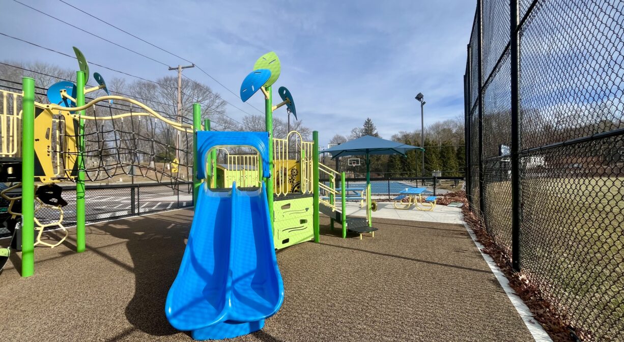 A photograph of a blue slide in a playground.