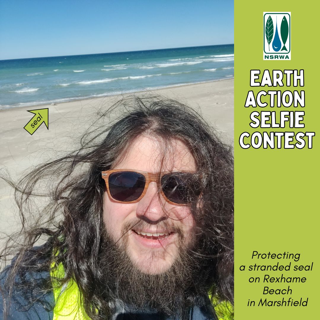 A photograph of a bearded man wearing a yellow safety vest, with an ocean beach in the background.