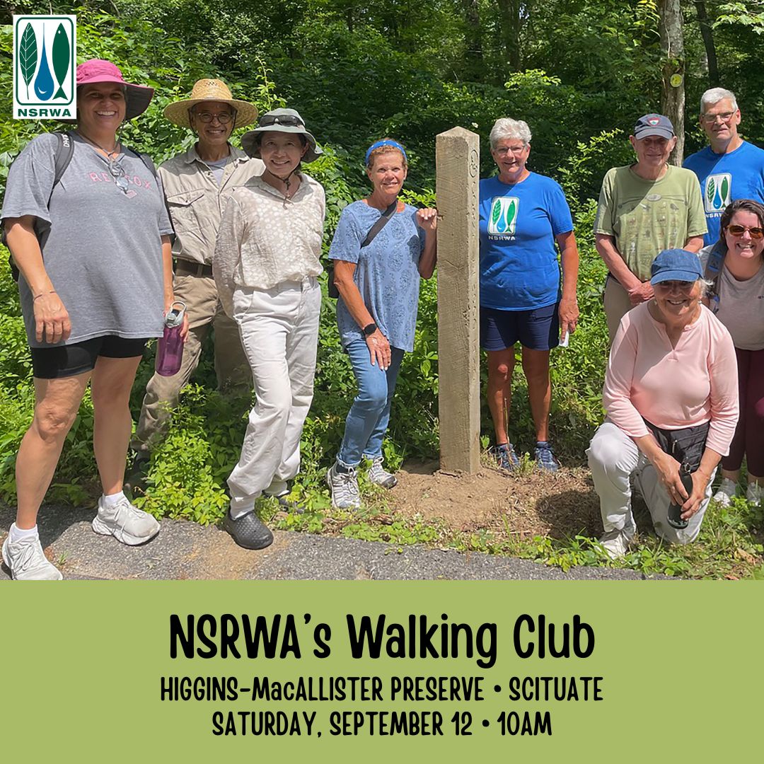 A photograph of a group of individuals standing by a trail marker.